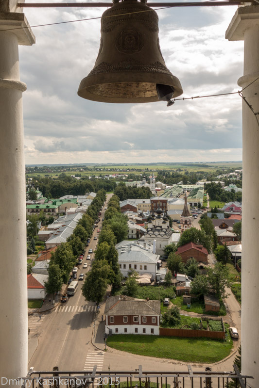Фото церковного колокола на фоне города. Суздаль