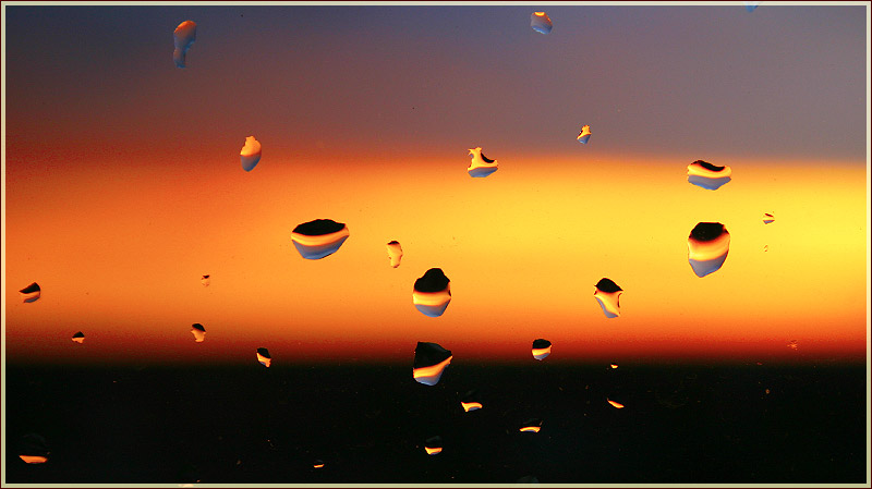 Капли дождя на стекле. Закат солнца после дождя