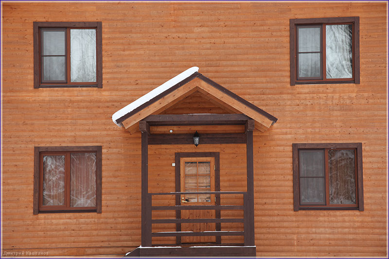 Стена деревянного дома. Крыльцо и окна